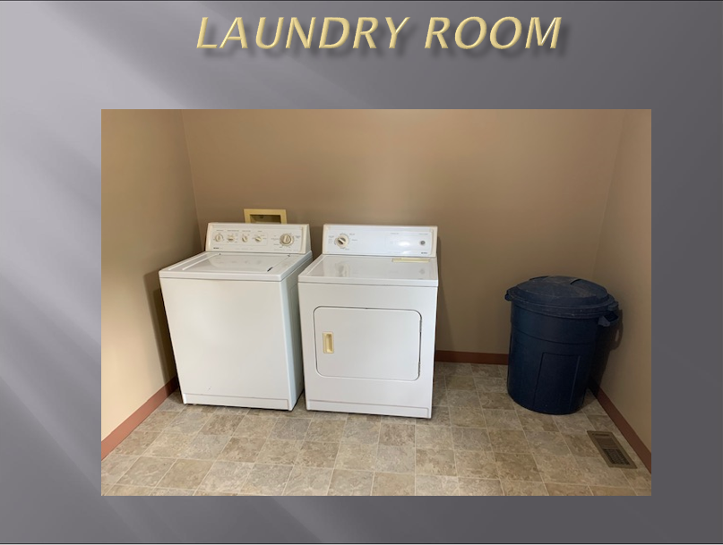 Laundry room with washer, dryer, and bin.