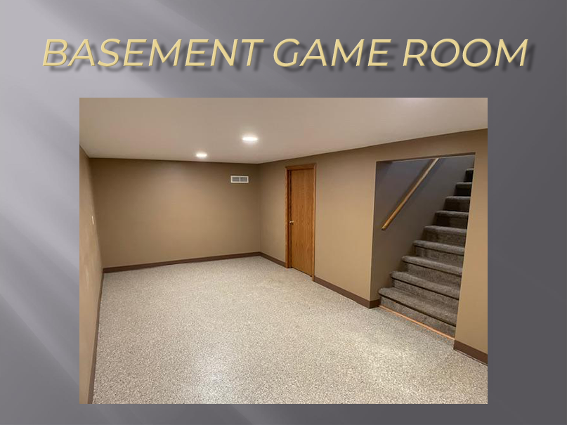 Empty basement game room with stairs.